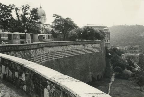 Turistabuszok a várfalnál, háttérben a Budavári Palota kupolája