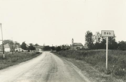 Béb település utca képe, háttérben a templommal.